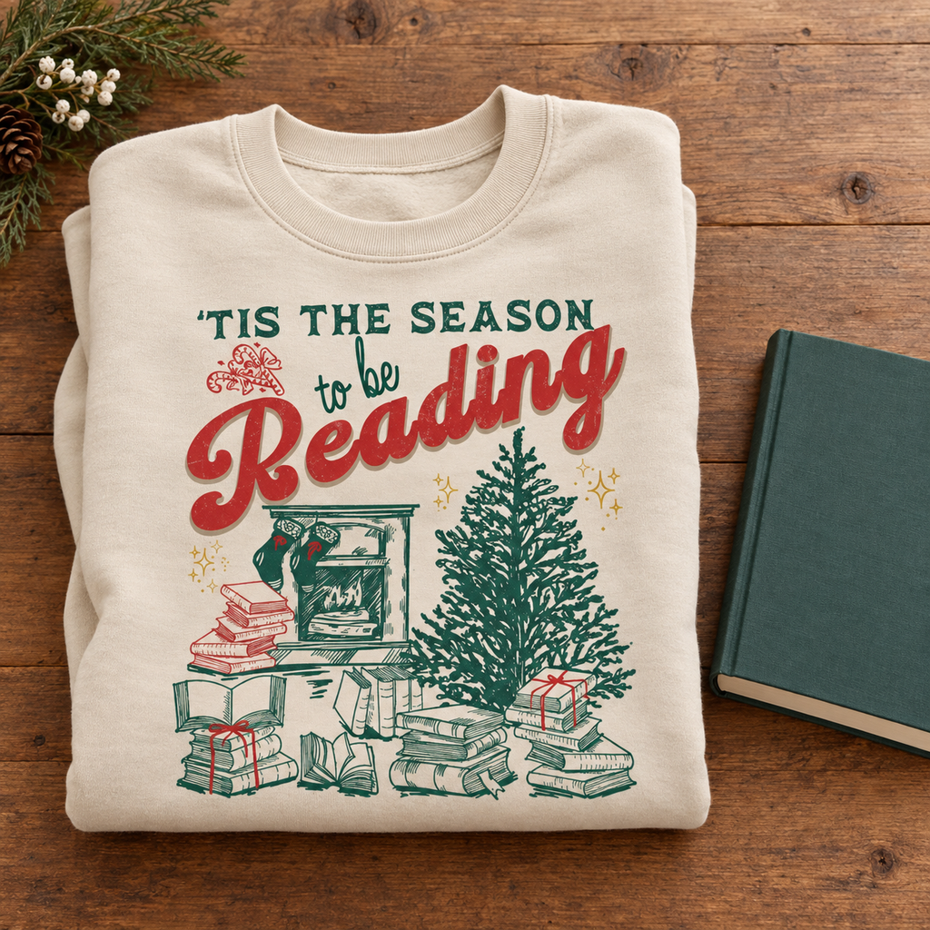 Sand book lover sweatshirt folded beside a book