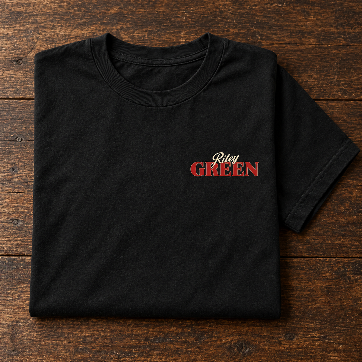 Black graphic tee folded on a wooden surface
